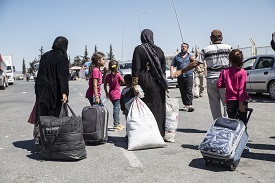 a group of people standing around a bag of luggage