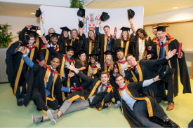 a group of people standing in front of a crowd posing for the camera