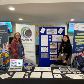 Two people by Converge information stand