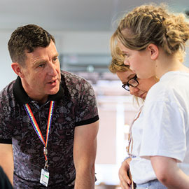 male member of staff providing guidance to female student and parent