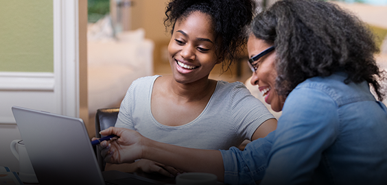 parent and child smiling and looking at a laptop