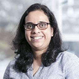 a person wearing glasses and smiling at the camera