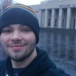 a man wearing a hat and smiling at the camera