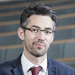 Alistair Rieu-Clarke wearing a suit and tie