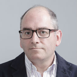 a man wearing glasses posing for the camera