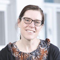 a woman in glasses looking at the camera