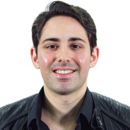 a man wearing glasses and smiling at the camera