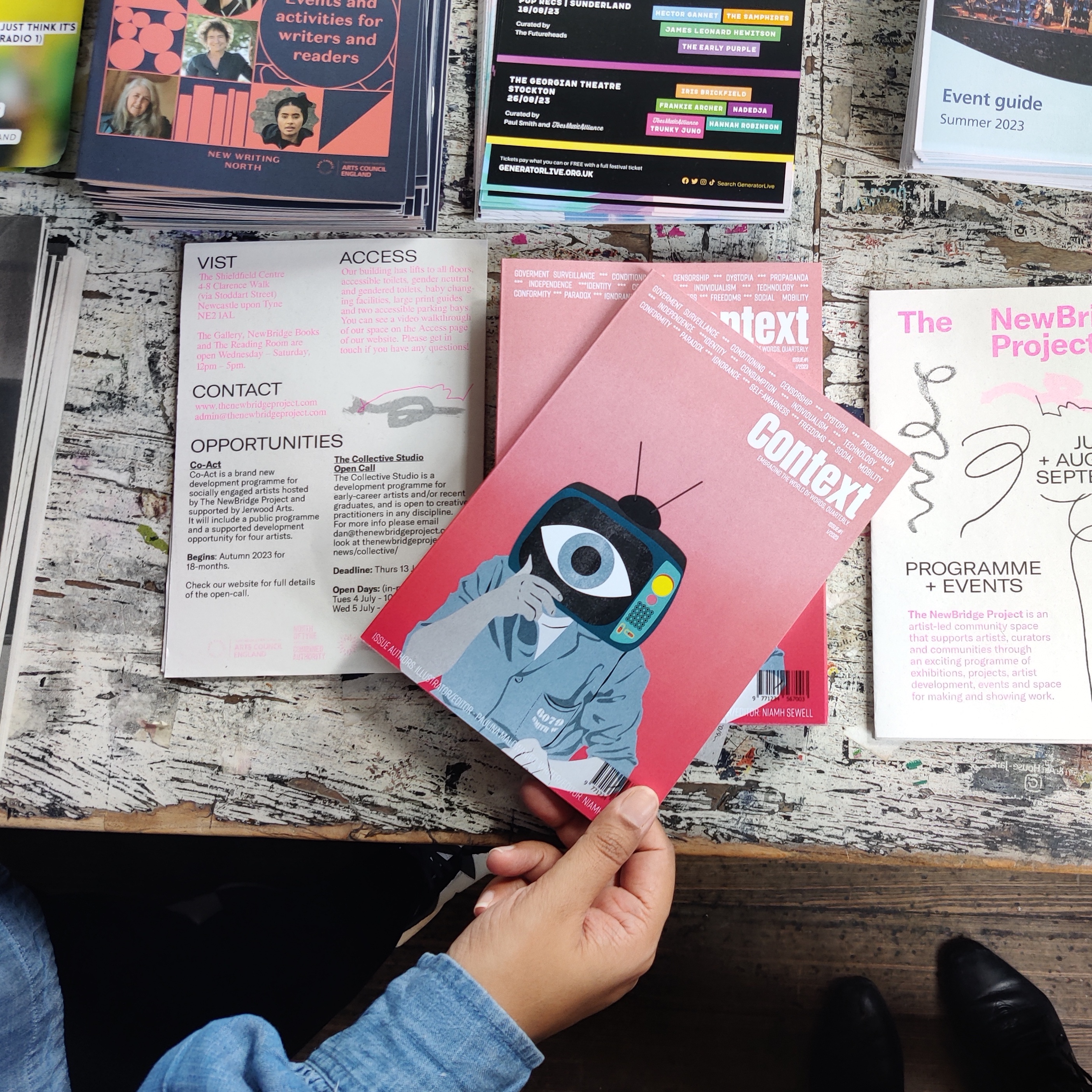 A hand picking up a magazine