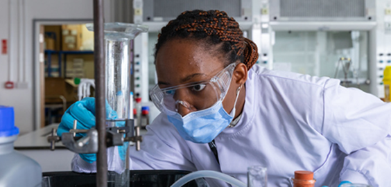 student in a laboratory working with test tubes and chemistry equipment  