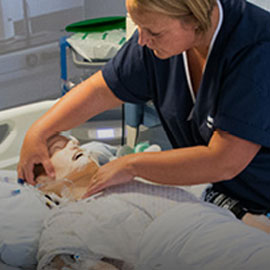 Student nurse examining manikin