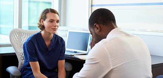 a man and a woman standing in front of a computer