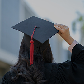 Back view of a girl holding her graduation cap