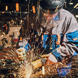 construction engineer cutting metal, sparks flying from machine
