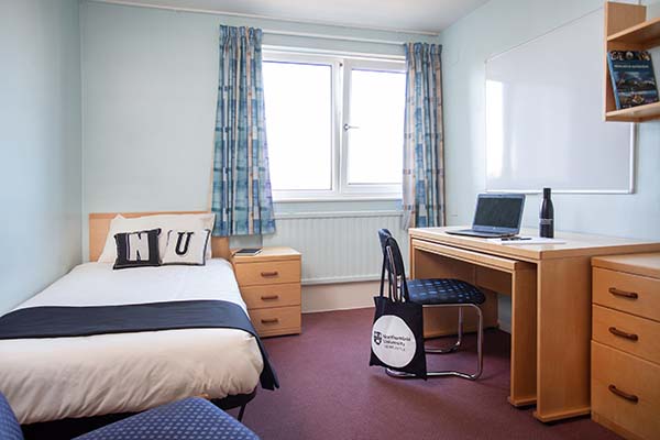 a bedroom with a bed and desk in a room