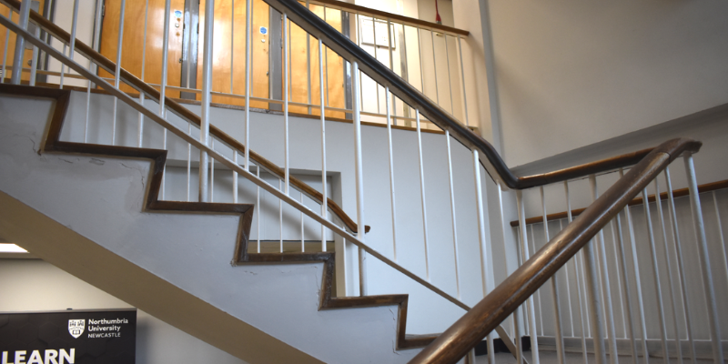 White staircase with wooden banister.