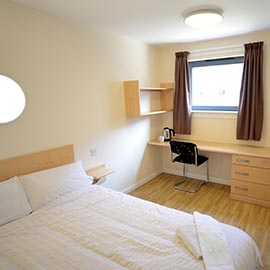 a bedroom with a bed and desk in a room