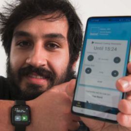 man smiling and holding a phone