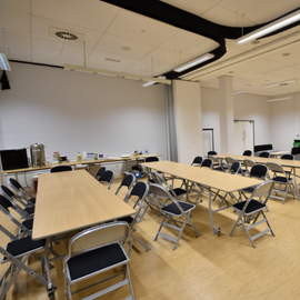 Small conference room filled with tables, chairs and sofas. 