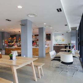 Cafe space with tables, chairs and counter in the background.