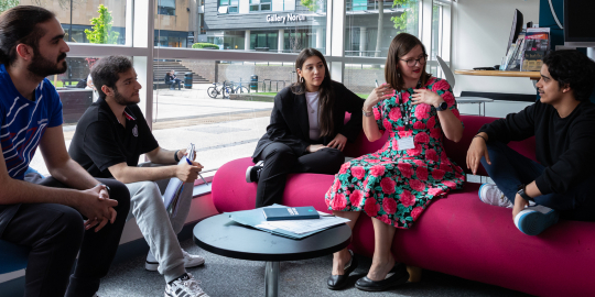 group of students sitting in a circle and listening to a mentor