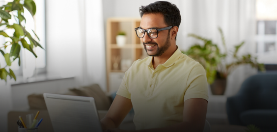 hands typing on keyboard next to notepad