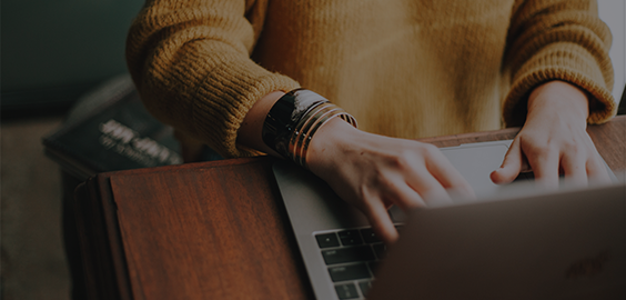 Turnitin: Improve Your Writing page menu button - person seated at desk typing on a laptop.
