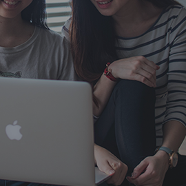 Two students looking at information on a laptop screen.