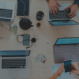 OneDrive: Secure Cloud Storage page menu button - people working on numerous laptops on a desk.