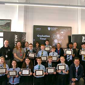 Students, staff and teacher standing inside the Great Hall with their High Tunstall certificates