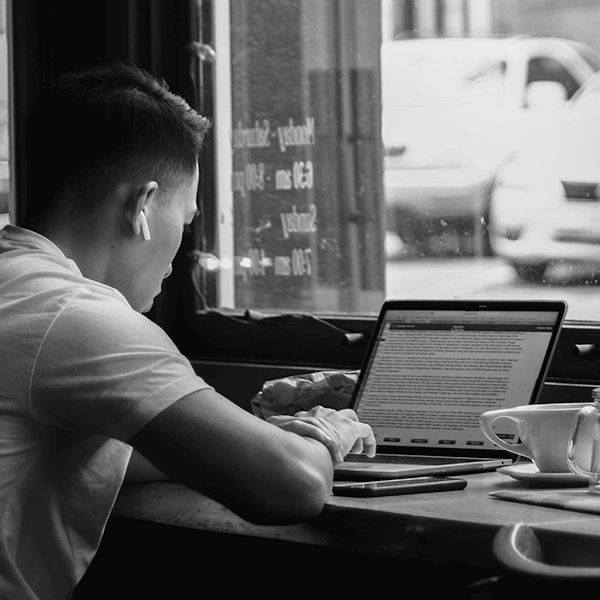 a person sitting at a table using a laptop computer