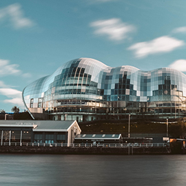 a large long train on Sage Gateshead over a body of water