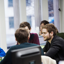 a group of people looking at a laptop