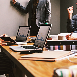 a group of people sitting at a table with a laptop