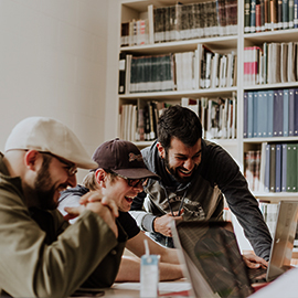 a group of people sitting at a table in a library