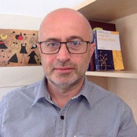 a man wearing glasses and smiling at the camera