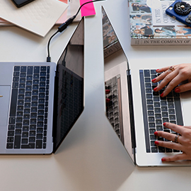 a person using a laptop computer sitting on top of a desk