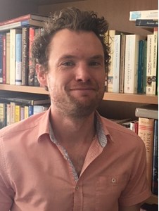 a man standing in front of a book shelf