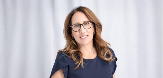 Northumbria Alumni smiling at camera, wearing blue dress