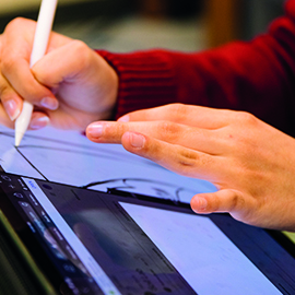 a person using a laptop computer sitting on top of a table