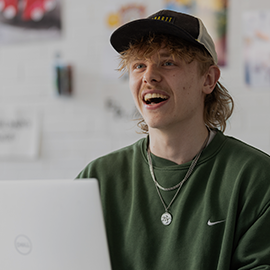 student smiling on laptop