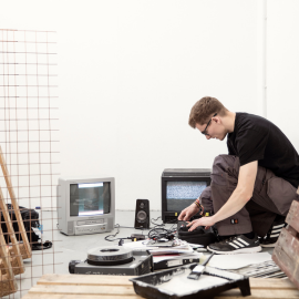Student working on art project that features old tvs