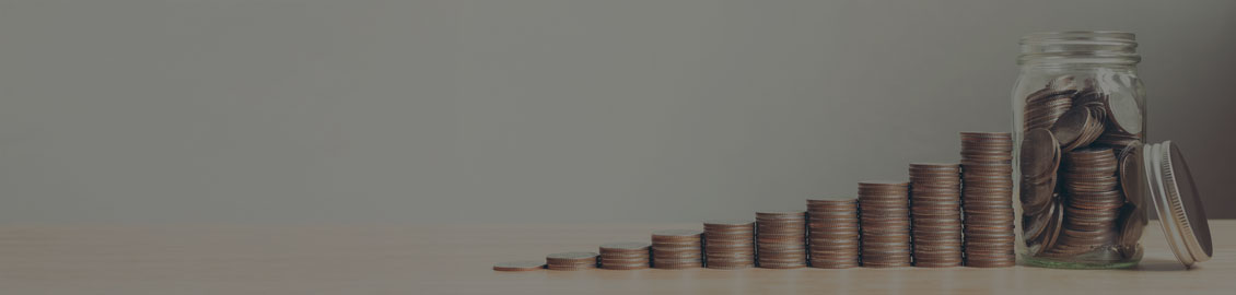 Image of coins piled up at various heights and coins also in a glass jar