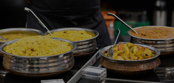 Image of food in metal bowls with ladle spoons