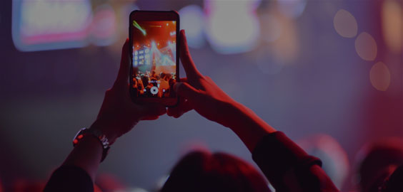 Image of person recording with their mobile phone at a concert