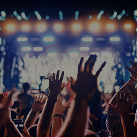 Image of people with their hands up in the air at a concert