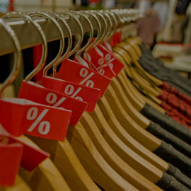 Image of clothes hanging on a rail with discount tags on the top of the hangers