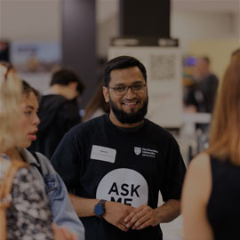 Image of male student working as an event rep during an open day and talking to visitors